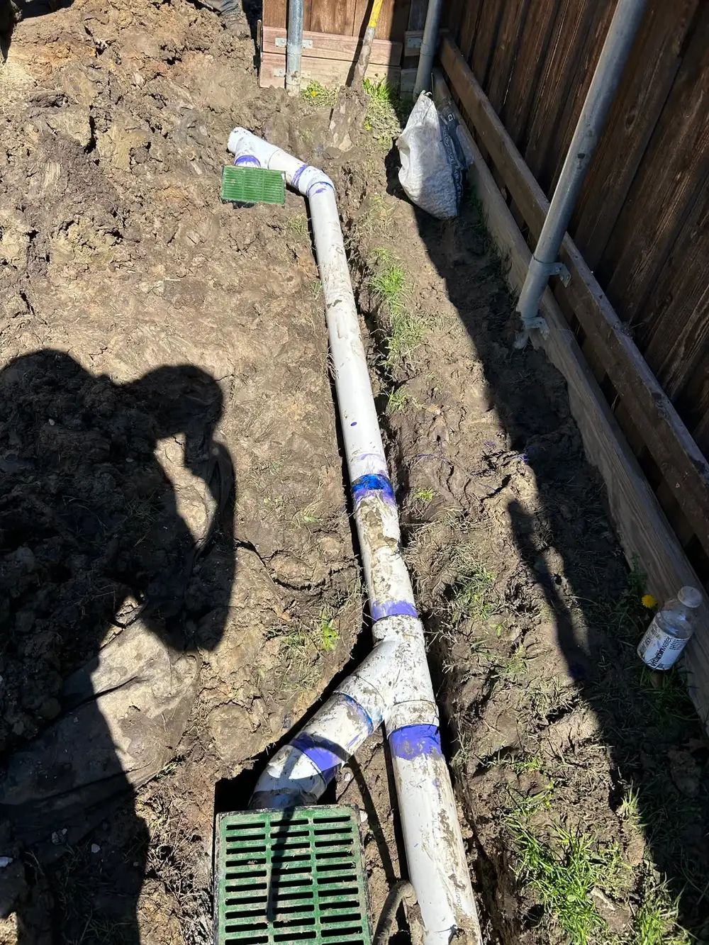 French drain pipe installation in backyard trench