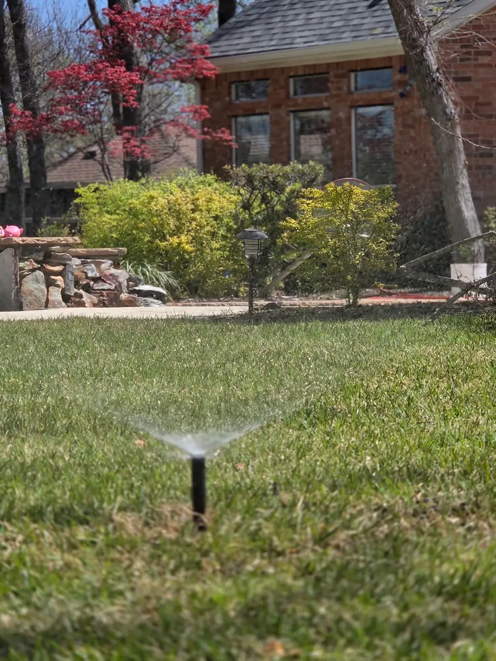 Sprinkler running with colorful spring landscaping